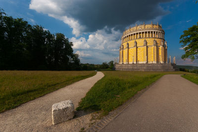 Road leading to built structure against sky