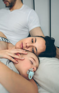 Family sleeping on bed at home