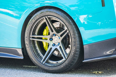 Close-up of blue car on road