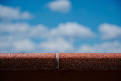 Close-up of metallic wall against blue sky