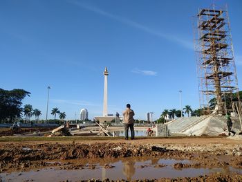 People working on bridge against sky