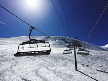 Overhead cable car on snow covered mountain against sky
