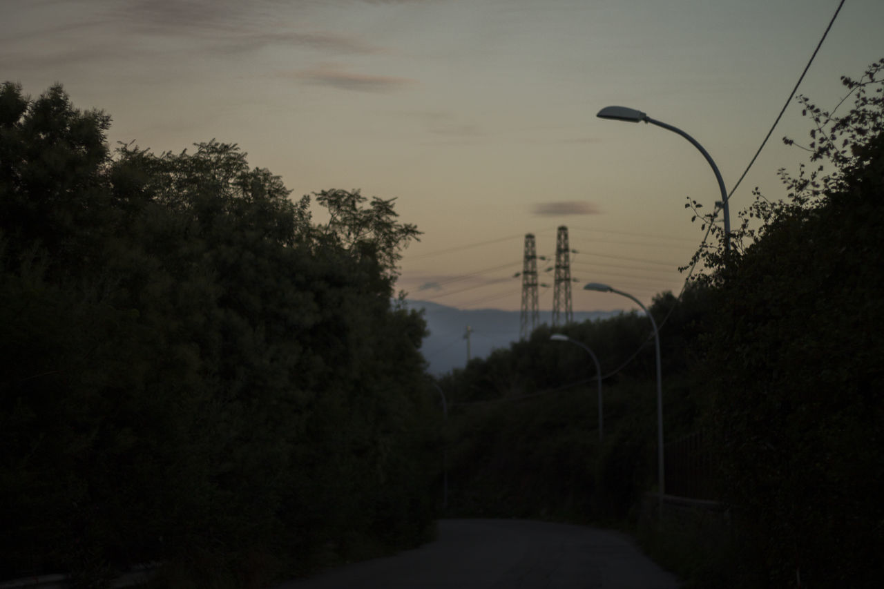 ROAD AMIDST TREES AGAINST SKY AT SUNSET