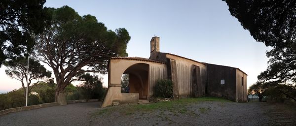 Road by building against clear sky