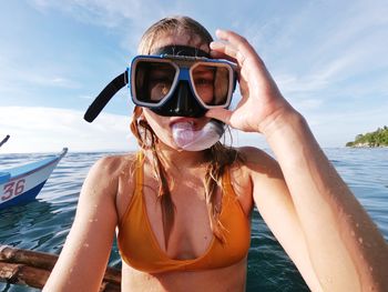 Woman wearing swimming goggles in sea