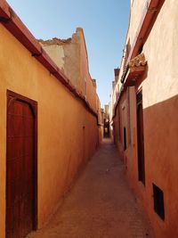 Narrow alley amidst buildings against sky