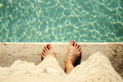 Low section of people relaxing on swimming pool