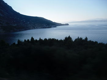 Scenic view of sea and mountains against sky