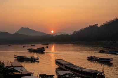 Wooden boats at the mekong river of luang prabang in laos southeast asia during the sunset time
