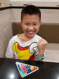 Portrait of smiling boy clenching fist at home