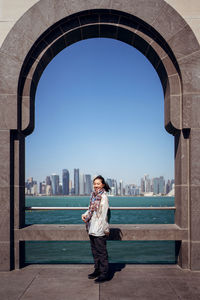 Full length of man standing by buildings against clear sky