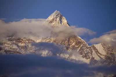 Low angle view of snowcapped mountains against sky