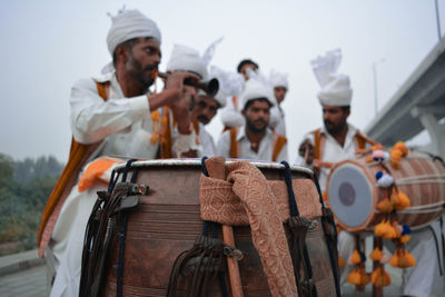 Men wearing traditional clothing playing musical instruments