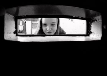 Portrait of a girl looking through window