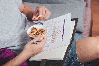 Midsection of woman holding book