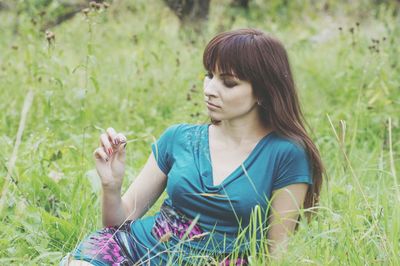 Woman sitting on grassy land