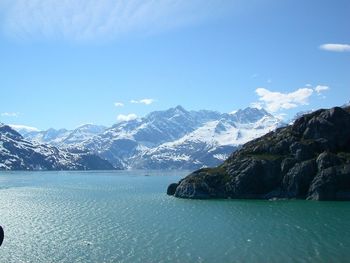 Scenic view of river by mountains against sky