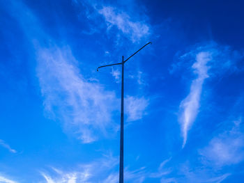 Low angle view of wind turbine against blue sky