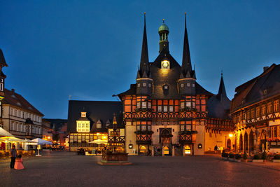 Exterior of historic building against clear blue sky in city at dusk