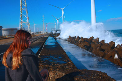 Rear view of woman by sea against clear sky