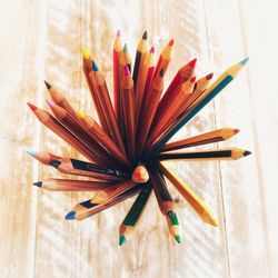 Directly above shot of colored pencils on wooden table