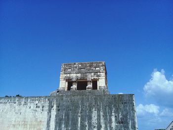 Low angle view of old building against blue sky