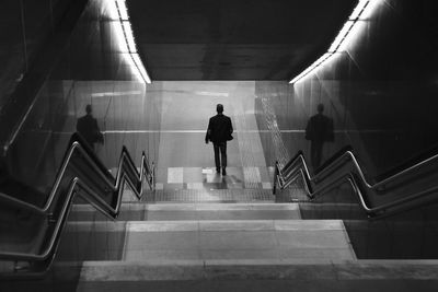 Rear view of man walking at subway station