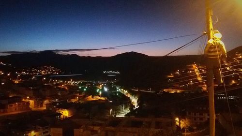 Illuminated cityscape against sky at night