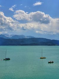 Sailboats in sea against sky