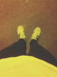 Low section of man standing on tiled floor