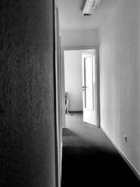 Rear view of woman sitting in corridor of building