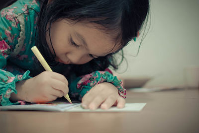 Close-up of girl writing in paper 