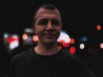 Portrait of young man against black background