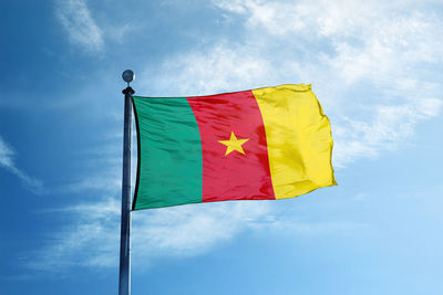 Low angle view of flag against blue sky