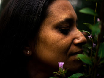 Close-up of woman smelling plants in park