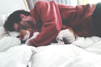 Man lying on bed at home with dog