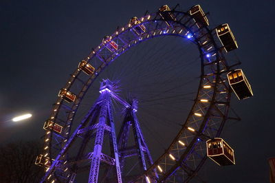 Low angle view of ferris wheel at night