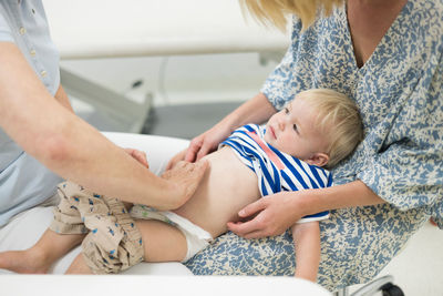 Midsection of doctor examining patient at home