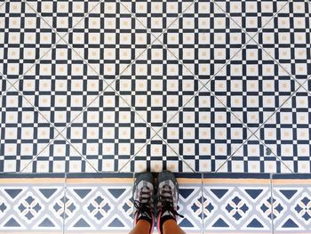 Low section of woman standing on tiled floor