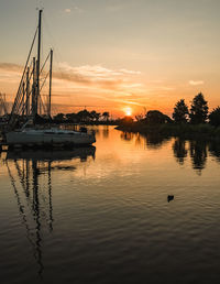 Silhouette sailboats in sea against sky during sunset