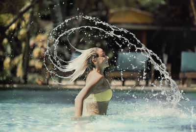 Close-up of woman splashing water