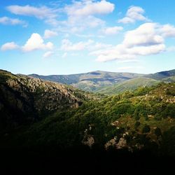 Scenic view of mountains against cloudy sky