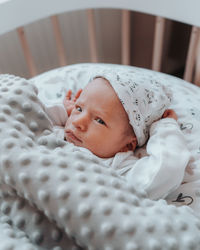 Portrait of cute baby lying on bed at home