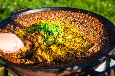 Close-up of man preparing food on barbecue grill in yard