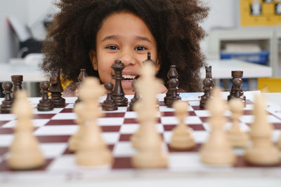 African american girl playing chess. happy smiling child. clever black kid with board game close-up