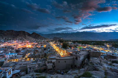 High angle view of illuminated town against sky at night