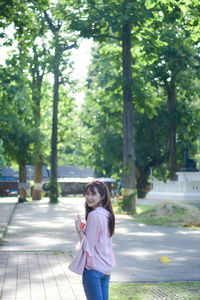 Portrait of young woman standing in park