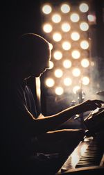 Side view of man playing piano