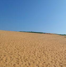 Scenic view of beach against clear blue sky