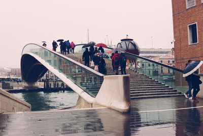 People on bridge against clear sky